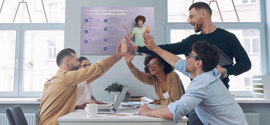 Diverse team celebrating success in a modern office environment.