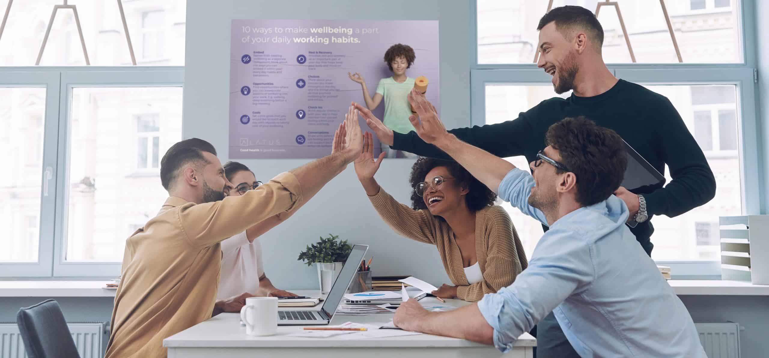 Diverse team celebrating success in a modern office environment.