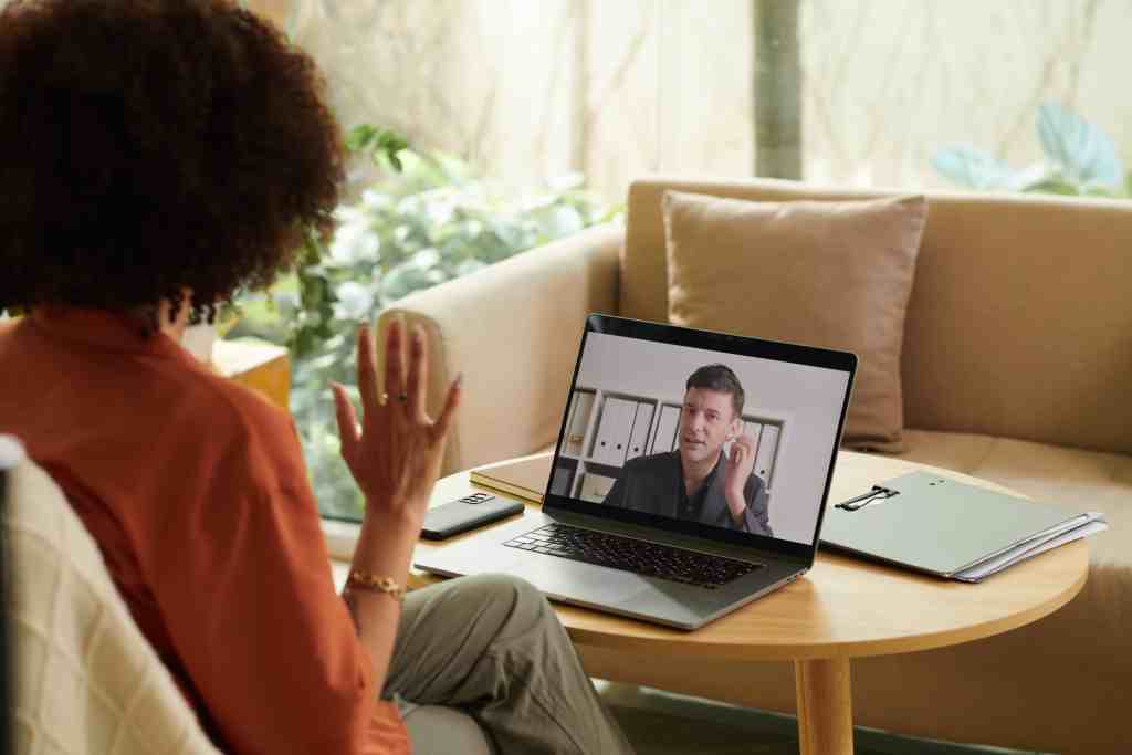 Woman participating in a virtual health surveillance consultation via laptop.