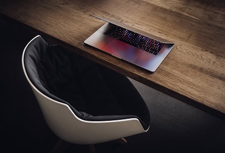 Modern workspace featuring a laptop and ergonomic chair for neurodiversity certification.