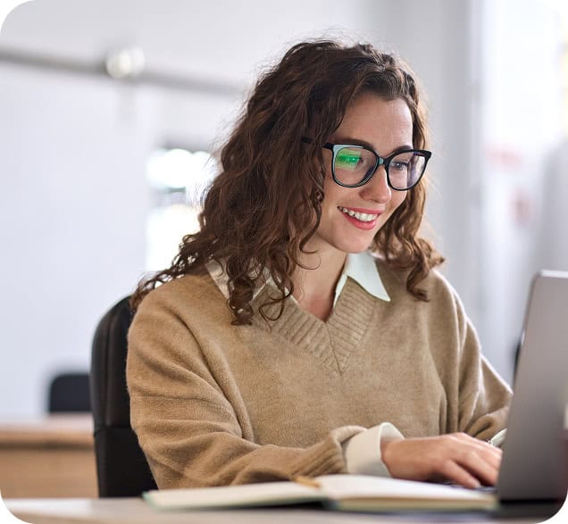 Professional woman working on a laptop in an office environment.