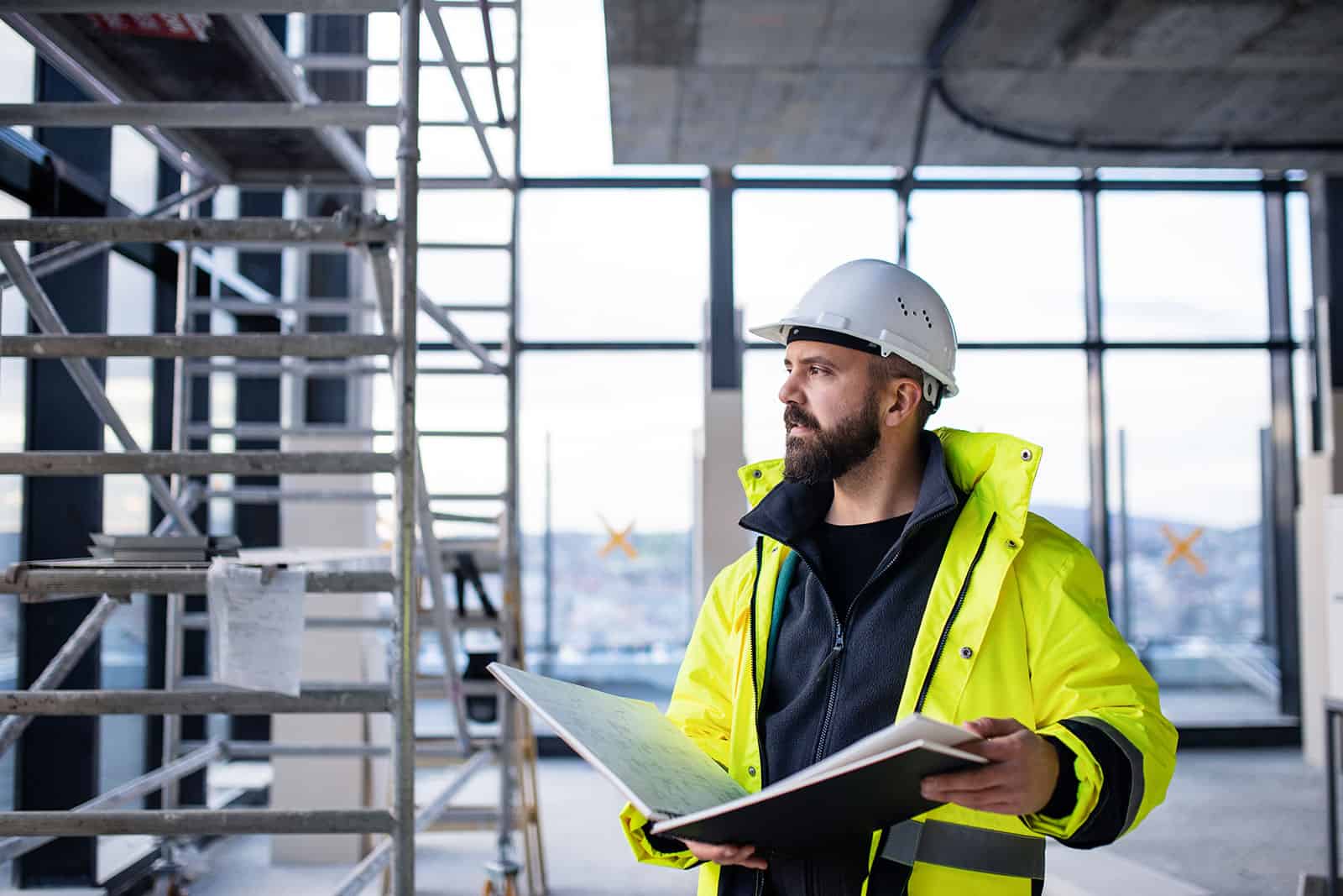 Construction worker in safety gear inspecting site health and safety measures.