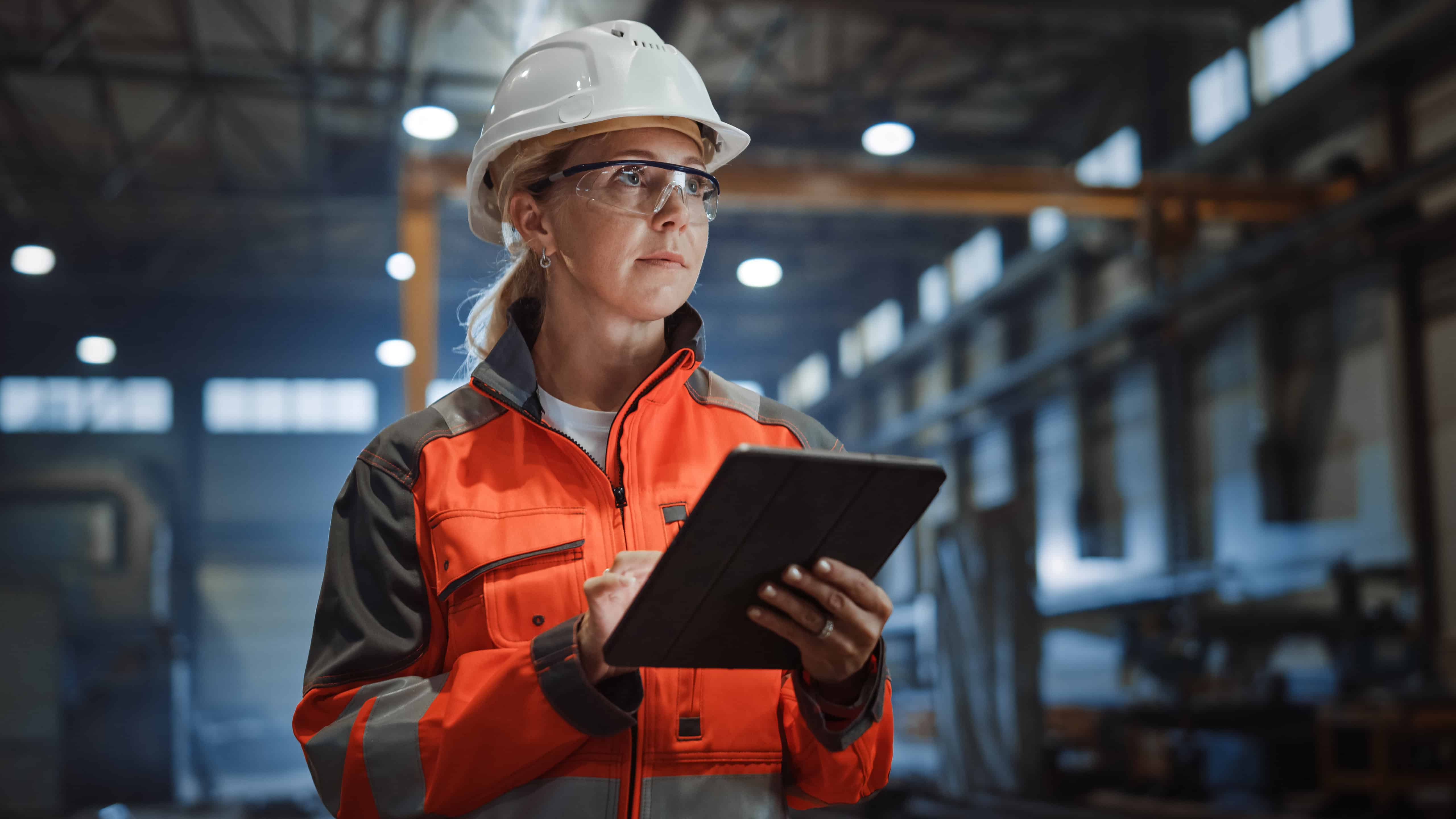 Female construction worker using a tablet at a building site.