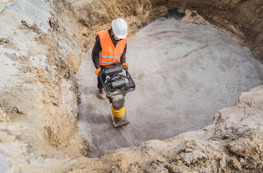 Worker using vibration control equipment in a construction site.