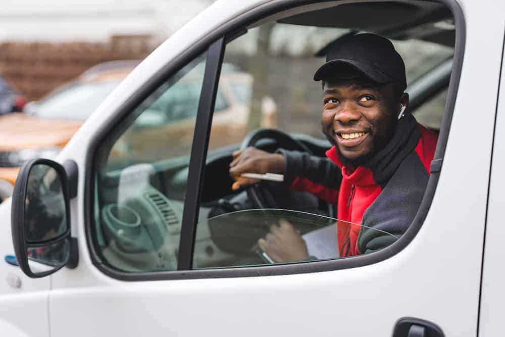 Medical driver in safety-critical role, smiling from the vehicle window.
