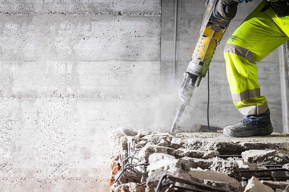 Worker using vibration-dampening tools for HAVS prevention.