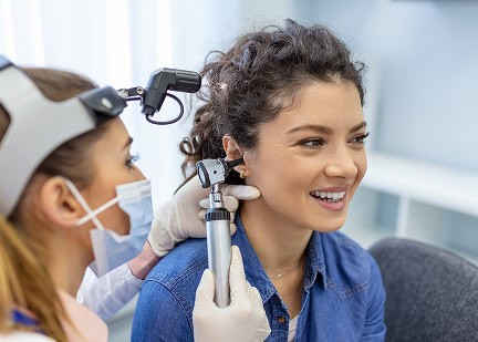 Audiologist performing a hearing test on a patient at NHS Audiology clinic.