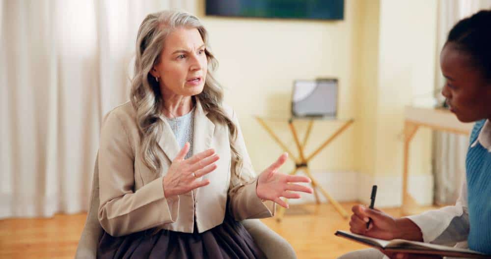 Woman receiving mental health support from a professional in a counselling session.