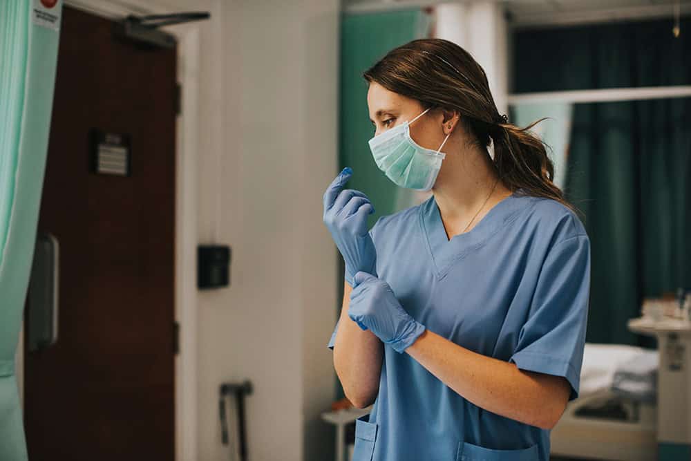 Healthcare professional preparing for patient care.