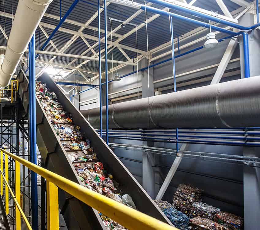 Recycling conveyor handling waste materials in a recycling plant.