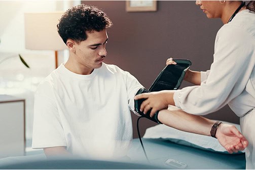 Patient having blood pressure checked in a healthcare setting.