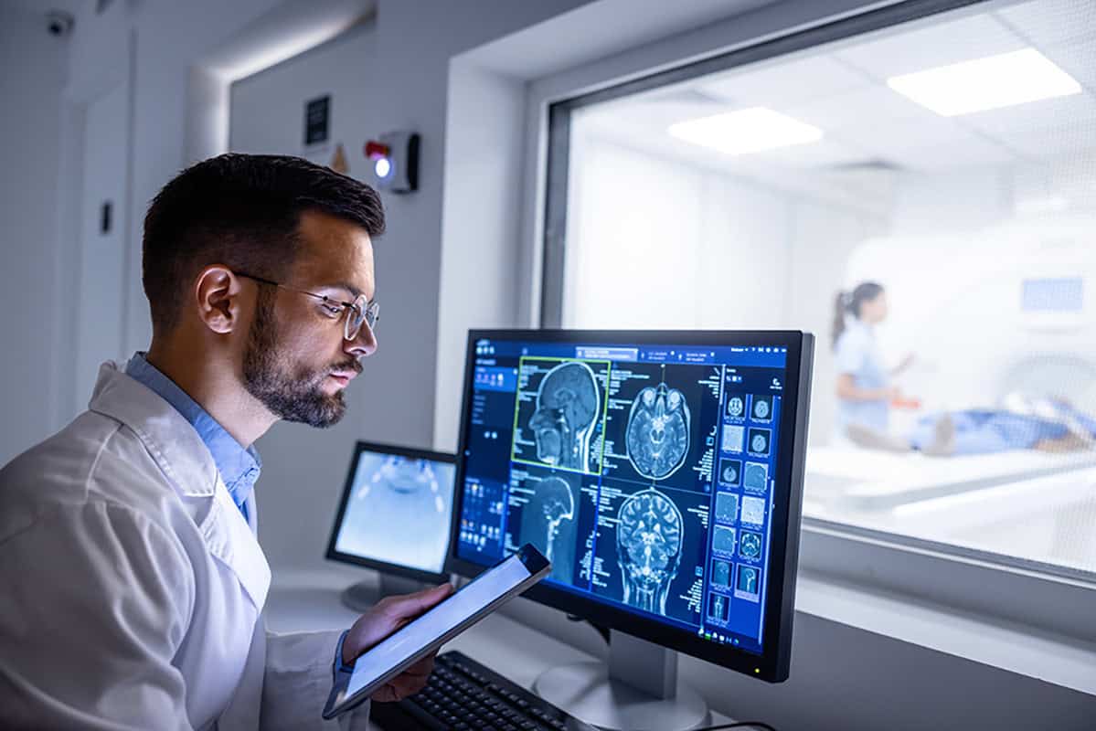 Medical professional reviewing brain scan images in a clinical setting.