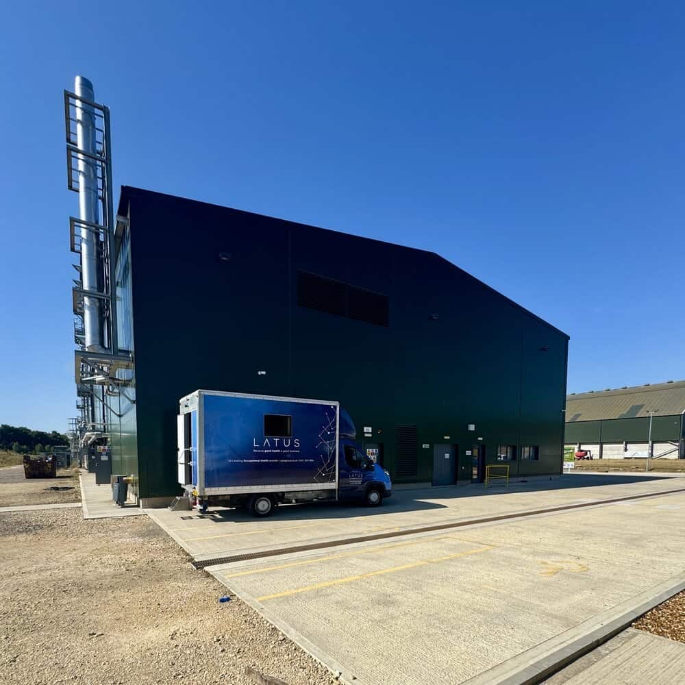 Modern industrial building with LATUS branding and delivery truck.