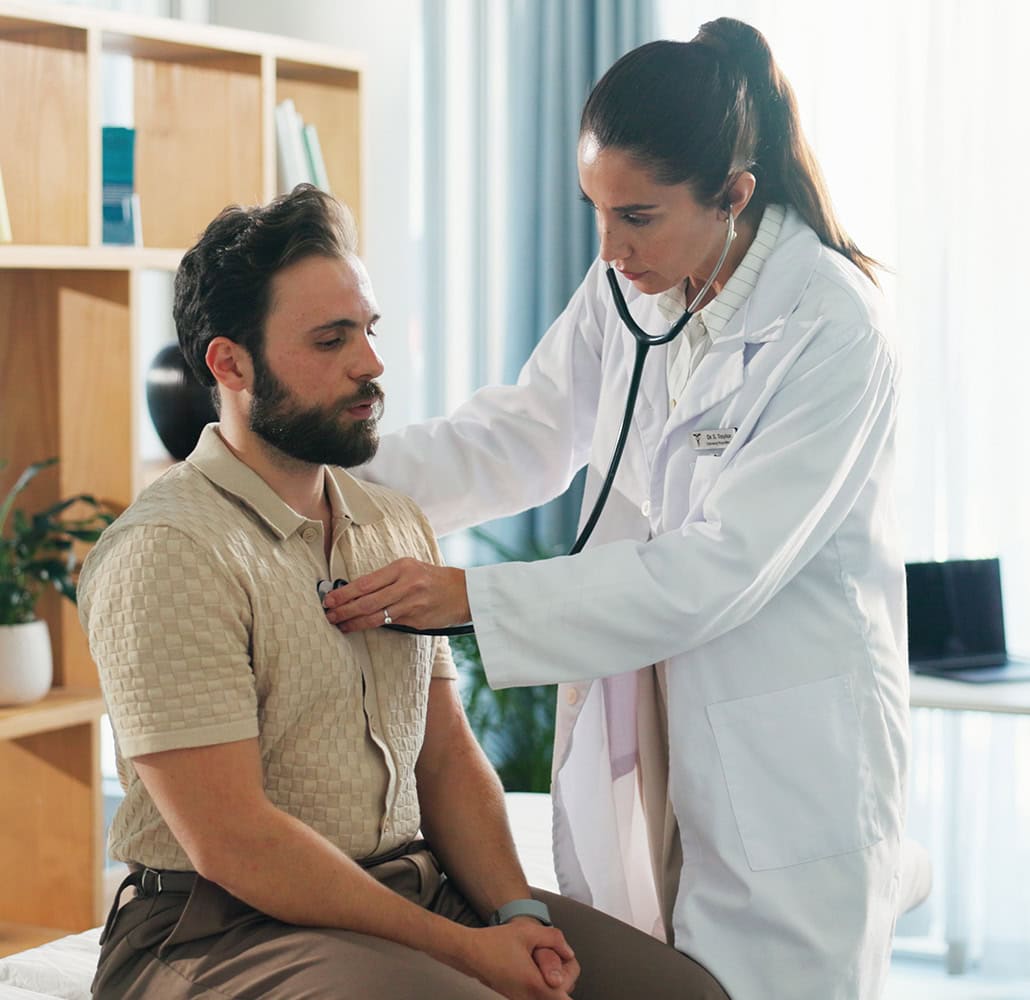 Doctor examining patient with stethoscope, providing healthcare support.