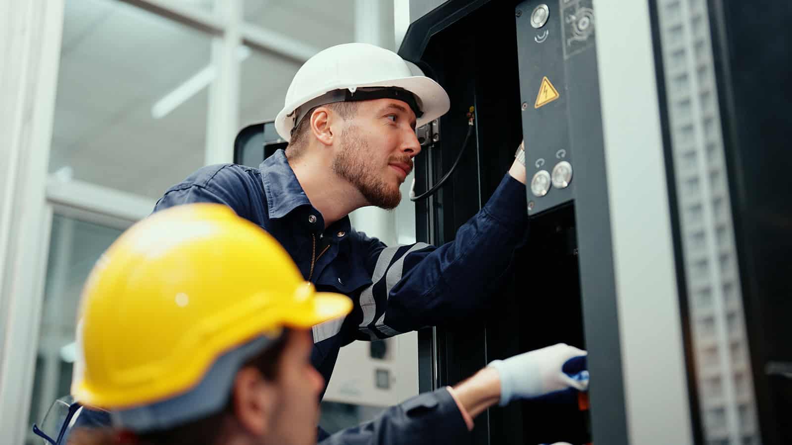 Electrical technician servicing medical electrical systems in a clinical environment.