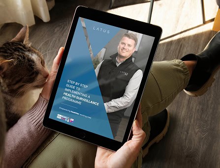Person holding tablet displaying health surveillance guide for workplace safety.