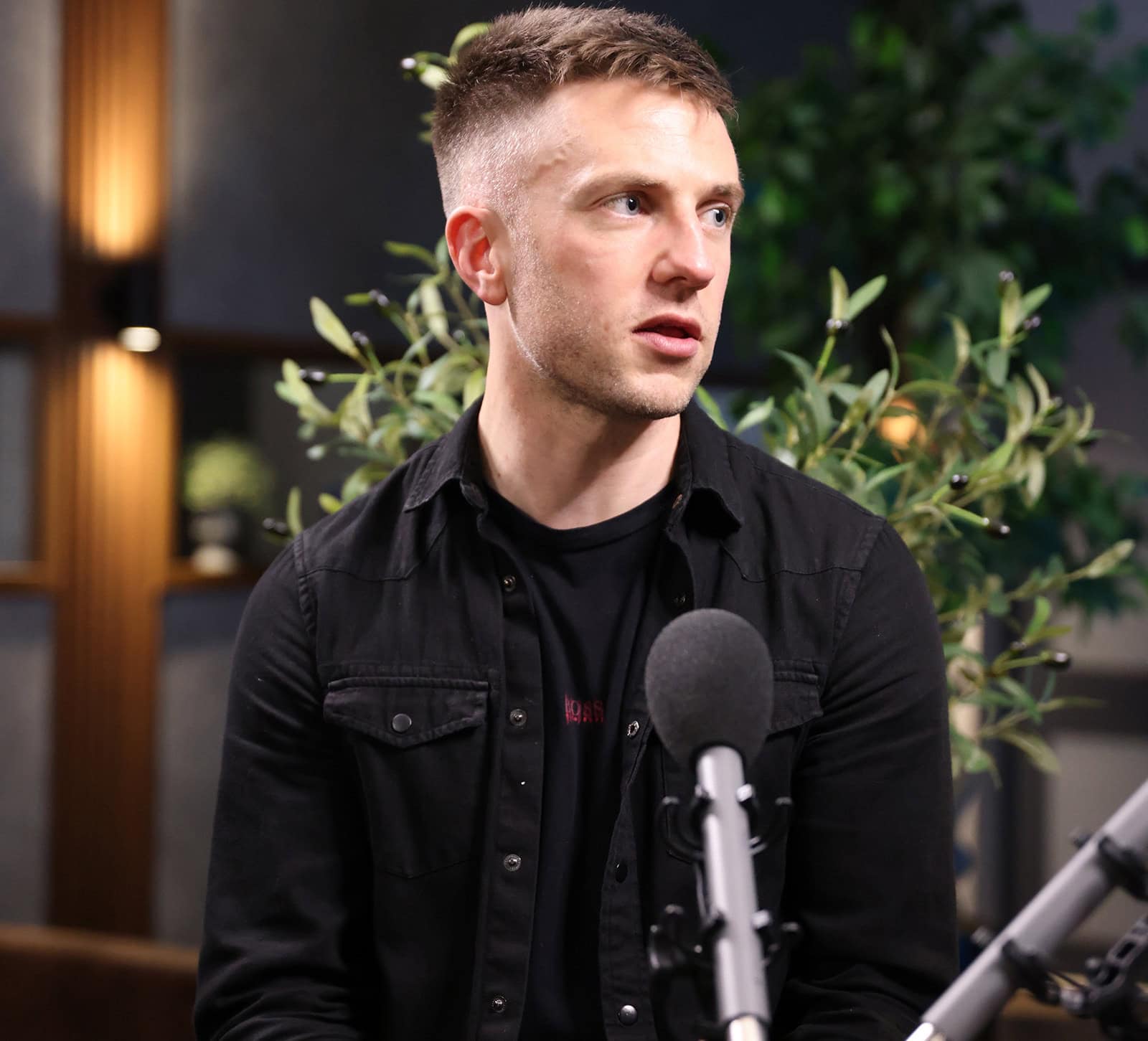 Podcast host speaking into microphone during LATUS Group podcast recording.