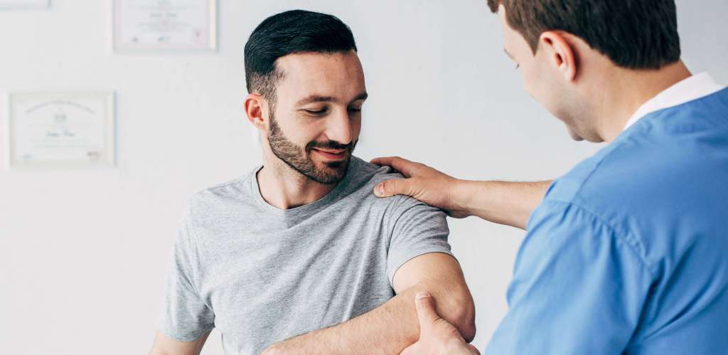 Physiotherapist providing workplace physiotherapy to employee.