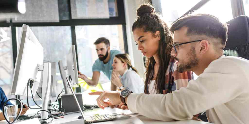 Team completing workplace health questionnaire on computers.
