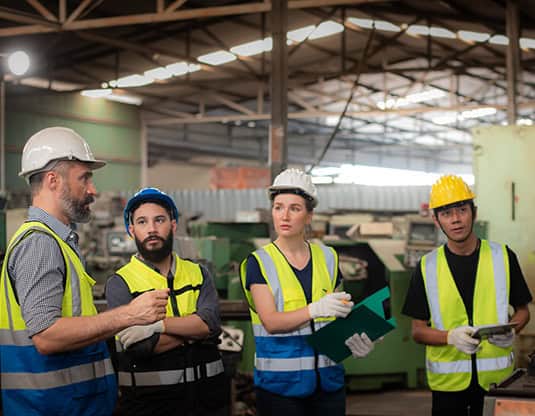 Health and safety training session with workers in industrial setting.