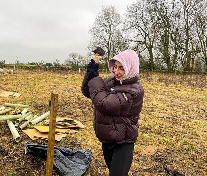 Woman planting trees outdoors demonstrating transparency and environmental commitment.