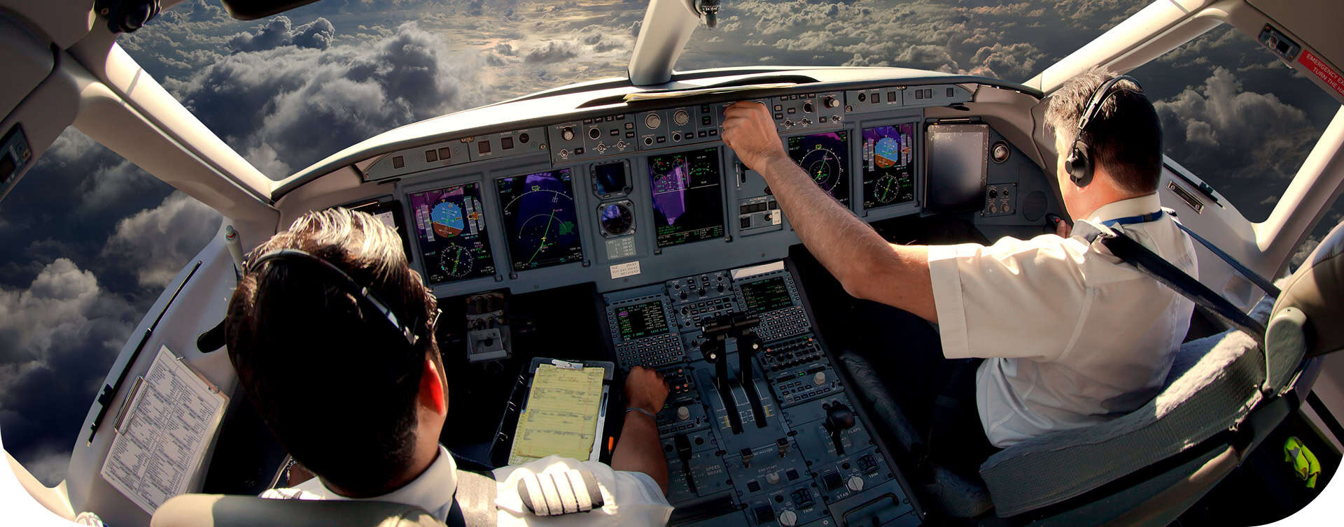 Aircraft cockpit with pilots and advanced navigation systems.