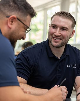 Business professionals discussing solutions at LATUS Group office.