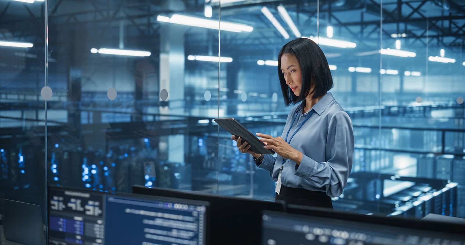 Businesswoman using tablet in a high-tech industrial environment.