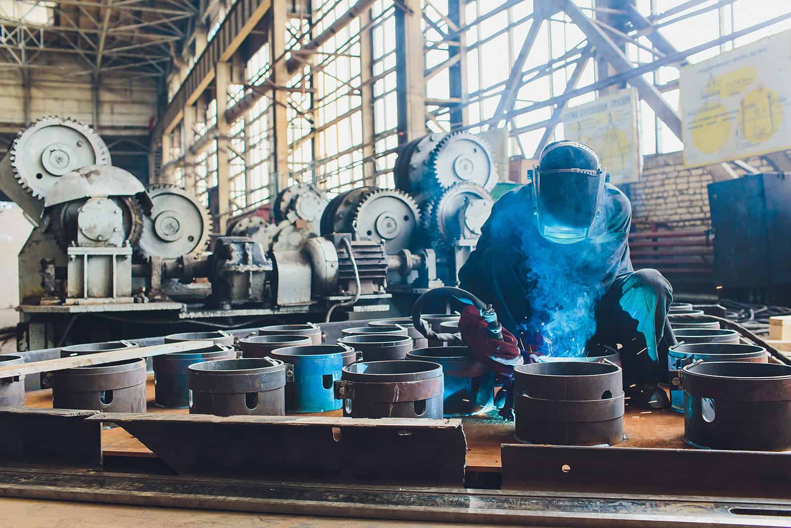 Industrial welding process in a manufacturing plant with heavy machinery.