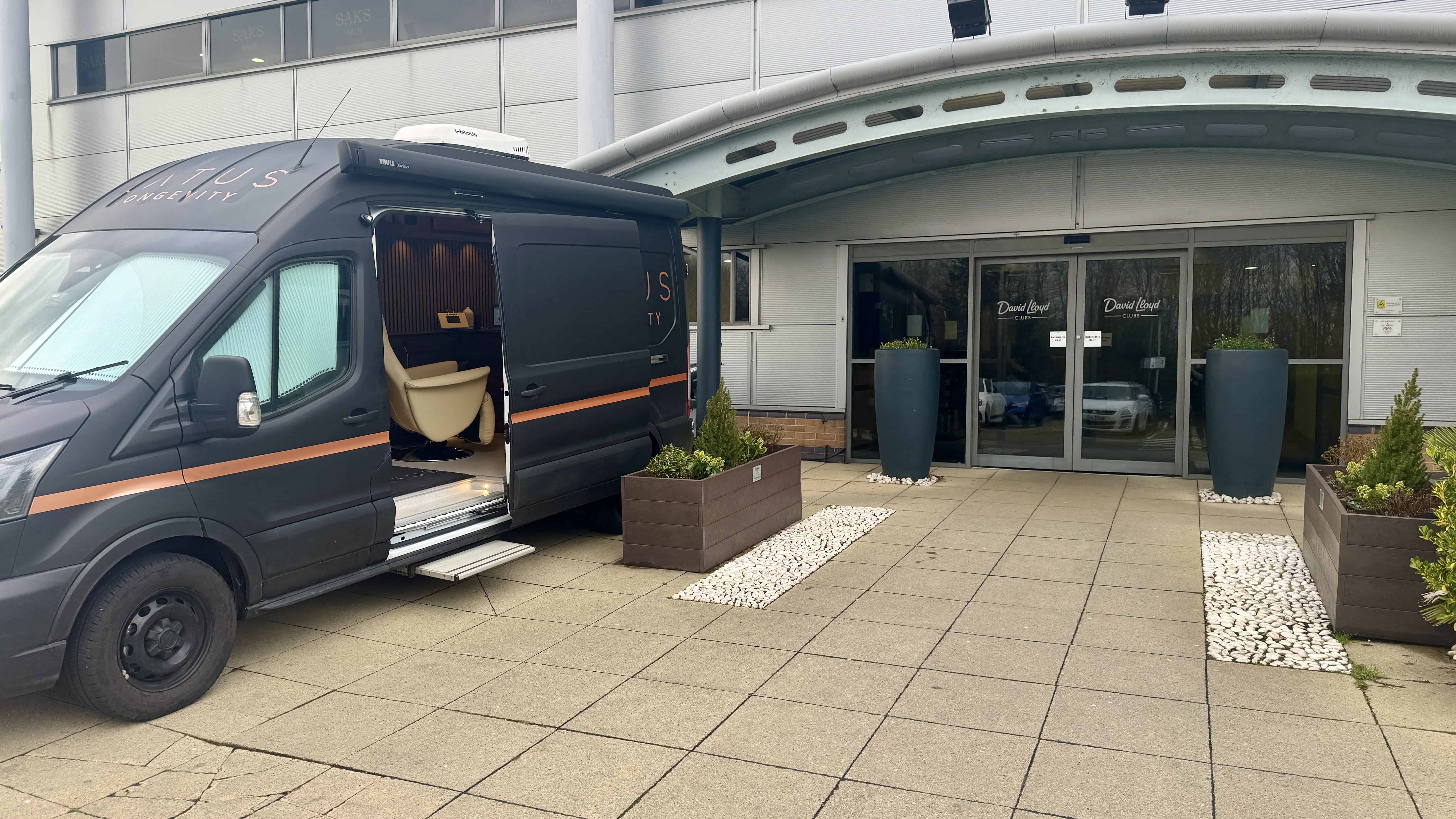 Modern office entrance with LATUS Group branding and a service van parked outside.