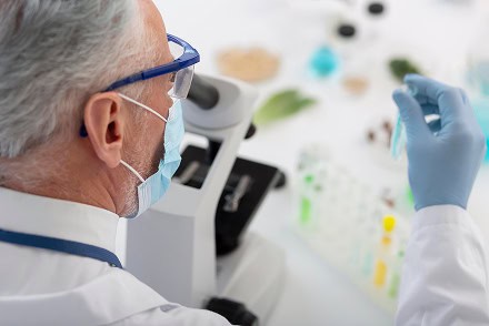 Healthcare professional using mobile health surveillance device in laboratory.