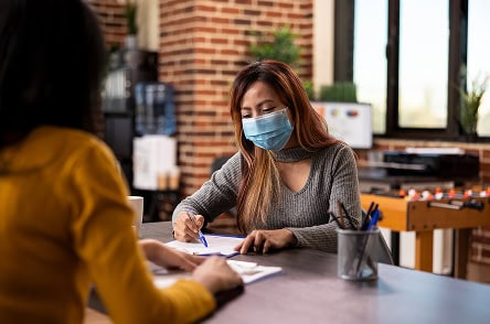 Woman using mobile health surveillance device in an office setting.