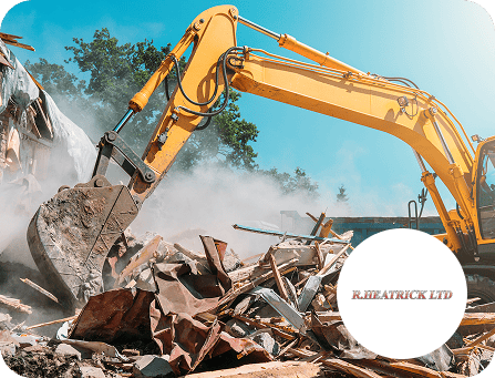 Excavator demolishing building debris for construction project.